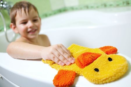 The boy in the bathroom, with a great mood and yellow sponge の写真素材