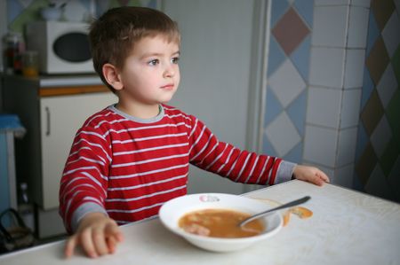 Boy who dreamily looks out the window during dinnerの写真素材