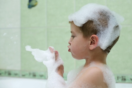 The boy takes a shower in the bathroom, with a cheerful moodの写真素材