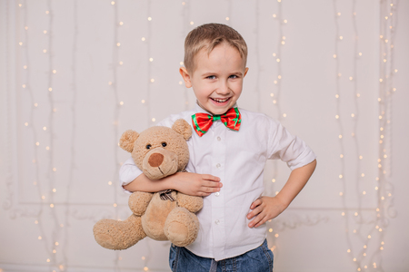 Joyful boy with his favorite toy teddy bear on handの写真素材