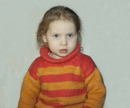 little blond girl in a sweater angry. White backgroundの写真素材