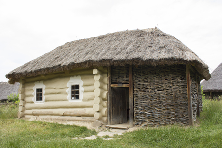 An old wooden house with thatched roofの写真素材