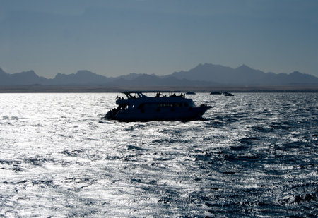 A motor boat, a yacht sails on the Red Sea against the backgrounの写真素材