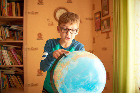 Boy with a globe. The boy in the glasses sees the globe