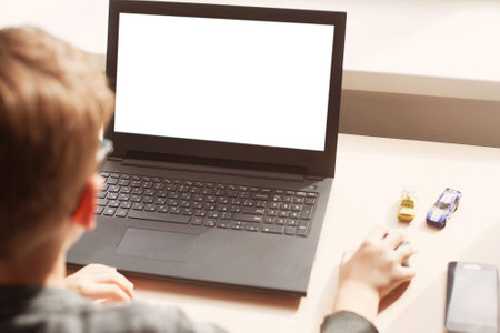 Happy boy sitting at his desk With laptop computerの写真素材