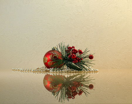 Christmas (New Year`s) composition of a Christmas ball, a fir-tree branch with berries and glittering beads on the mirror surface with reflectionの写真素材