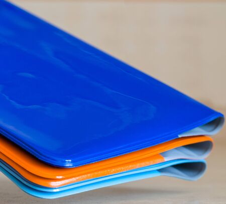 Roots of multi-colored shiny passport covers at an angle in the air. Close-up shot