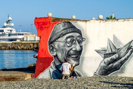 Sochi, Russia - July 20, 2019: artist paints graffiti with Jacques Yves Cousteau on the concrete structure of the sea beach. Overall planのeditorial素材