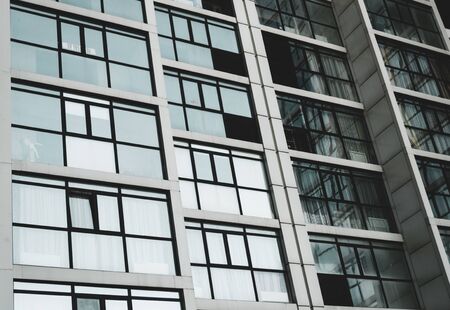 Part of the facade of the building made of glass and concrete with highlights on the windows....