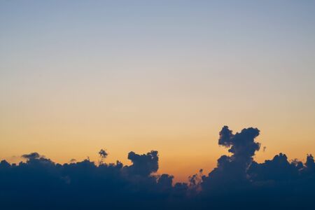 Dark clouds at sunset, illuminated by the red rays of the sunの写真素材
