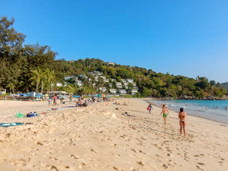Kata Noi Beach, Phuket, Taliand - May 10, 2016: sandy beach with people stretching into the distance. Bungalow on the hill. Turquoise sea and blue skyのeditorial素材