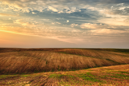 hilly field. a picturesque sky over a hilly fieldの写真素材
