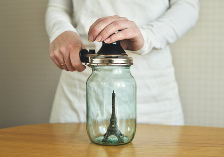 Eiffel tower in a glass jar in a woman's handの写真素材