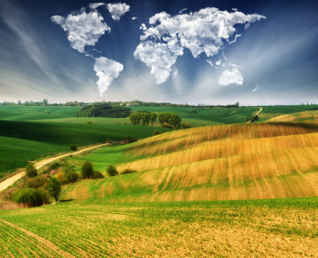 clouds in the form of a map of the world over the field. Travel and landscape concept. hilly field