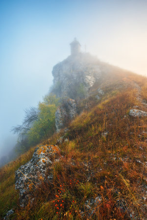 Church on the rock. Autumn landscape with fog. Nature of Ukraineの写真素材