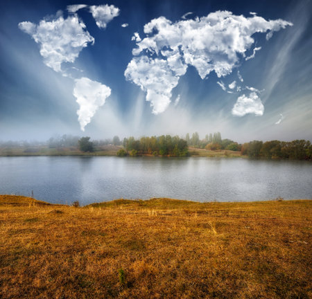 Autumn landscape with a lake and clouds in the form of heartの写真素材