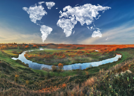Autumn landscape with river and clouds in the form of a heartの写真素材