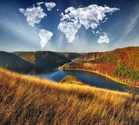 clouds in the form of a world map over the river canyon. Travel and landscape concept. autumn morningの写真素材