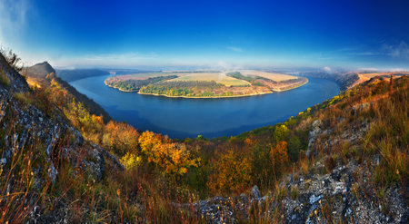 Autumn morning. Traveler on the top of rocks above river valley with thick fog. Natureの写真素材