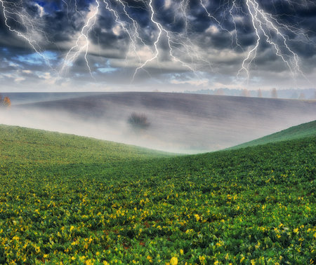 thunderstorm in the field. huge lightning over a hilly field. bad weather in the field.の写真素材