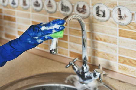 Close-up of a filthy kitchen tap covered in cleaning foamの写真素材