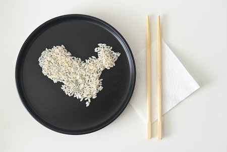 Uncooked white rice grains arranged into a map of China, presented on a minimalist black plateの写真素材