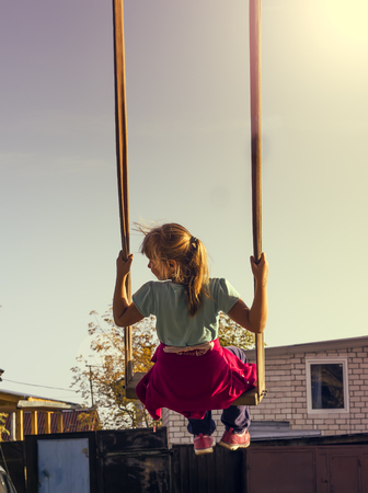 Young  girl on swing in the gardenの写真素材
