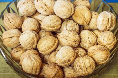 Walnuts in a glass plate on a blue backgroundの写真素材