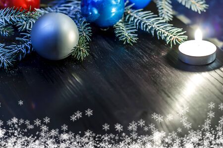 Christmas background. Spruce branch on the wooden background with the light of candlesの写真素材