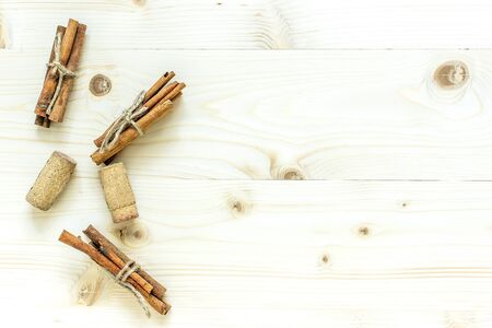 Cinnamon sticks and cork from wine on a wooden backgroundの写真素材