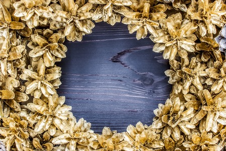Golden pine cones around a wooden backgroundの写真素材