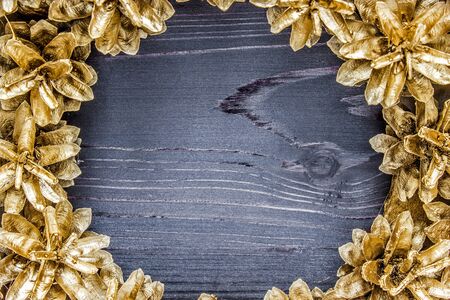 Golden pine cones around a wooden backgroundの写真素材