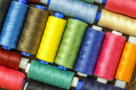 Bobbins with colorful threads on old wooden table background, Sewing backgroundの写真素材