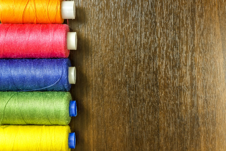 Bobbins with colorful threads on old wooden table background, Sewing backgroundの写真素材