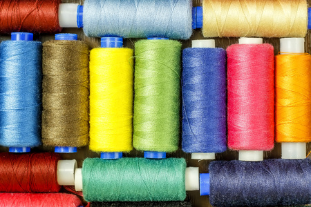 Bobbins with colorful threads on old wooden table background, Sewing backgroundの写真素材