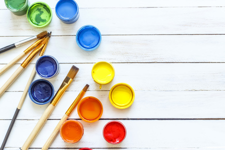 Paints and brushes on a white wooden backgroundの写真素材