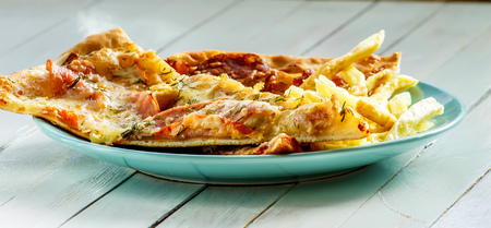 Pizza, French fries on the plate on white wooden backgroundの写真素材