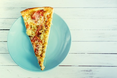 Pizza on a blue plate on a white wooden background. Retro styleの写真素材