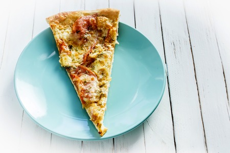 Pizza on a blue plate on a white wooden backgroundの写真素材