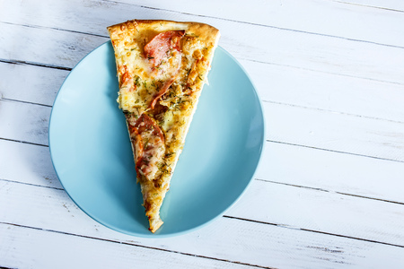 Pizza on a blue plate on a white wooden backgroundの写真素材