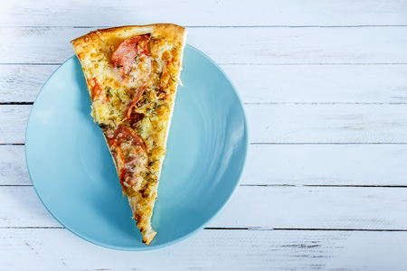 Pizza on a blue plate on a white wooden backgroundの写真素材