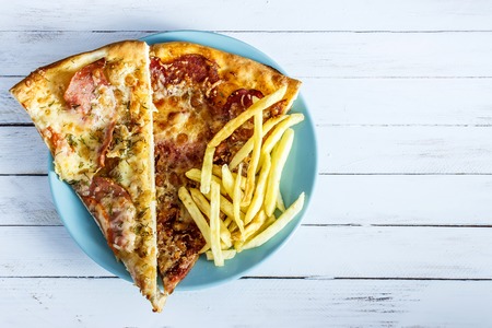 Pizza, French fries on the plate on white wooden backgroundの写真素材