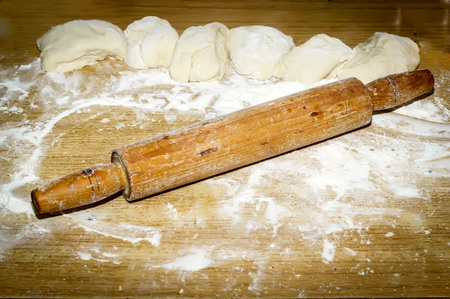cooking, baking and home concept - close up of bread dough and utensils on cutting boardの写真素材