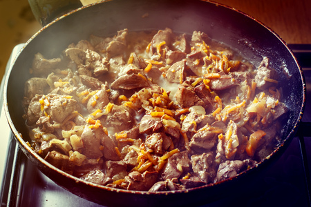 Liver fried with carrot is cooked in a frying panの写真素材