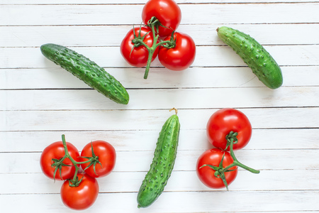 Fresh cucumbers and tomatoes on a white wooden background. Place for text.の写真素材