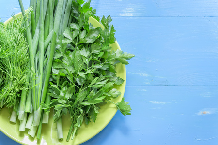 Parsley dill and onion on a blue background. Healthy eating.の写真素材