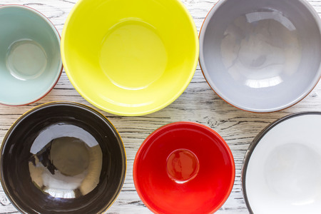 Empty color plates and utensil on wooden table background, top view with copy spaceの写真素材