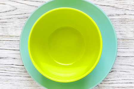 Empty color plates and utensil on wooden table background, top view with copy spaceの写真素材