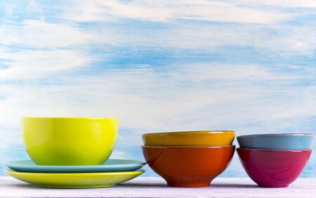 Empty color plates and utensil on wooden table background, with copy spaceの写真素材