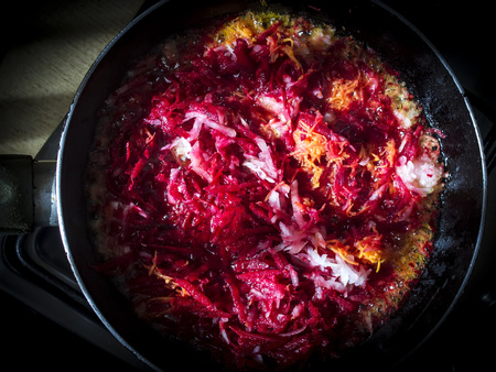Carrots, beets and onions in a frying pan, around dill, on a brown wooden background. Ingredients for borsch.の写真素材